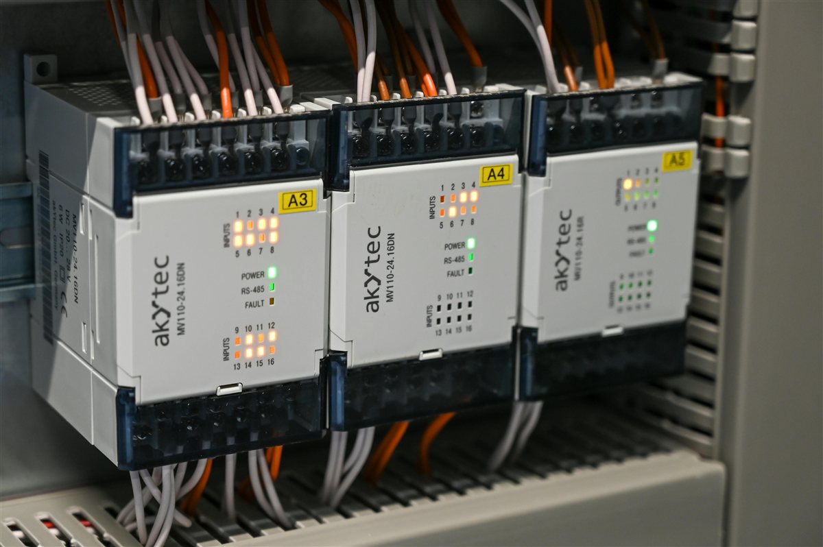 Technician inspecting and servicing industrial control panel in the field